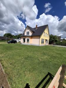 a white house with a yard with a house at Ferienwohnung Küstennah in Großenwiehe