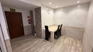 a dining room with a wooden table and chairs at Pension GAZTELUGATXE in Bermeo