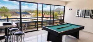 a pool table in a room with a large window at Casa Oasis Aguascalientes in Cañada del Rodeo