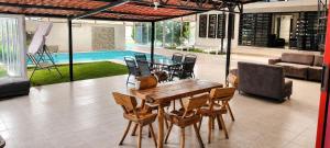 a wooden table and chairs in a room with a pool at Casa Oasis Aguascalientes in Cañada del Rodeo