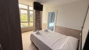 a bedroom with a bed and a large window at Pension GAZTELUGATXE in Bermeo