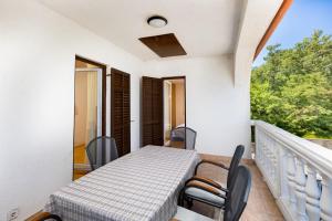 a room with a table and chairs on a balcony at Rooms Vera in Porat +30 photos