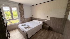 a small bedroom with a bed and a window at Pension GAZTELUGATXE in Bermeo +11 photos