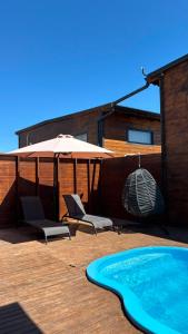 a patio with an umbrella and chairs and a swimming pool at Villa Myra in Beymelek