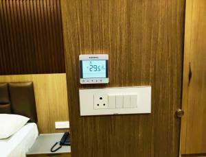 a clock on a wall in a hotel room at Hotel Royal Stay in Madurai +37 photos