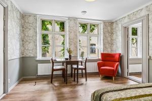 a bedroom with a table and chairs and windows at Det gamle Apotek Møn in Stege +18 photos