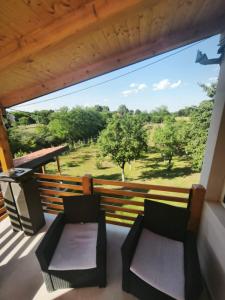 a balcony with two chairs and a view of the savannah at Peščani breg in Banatski Karlovac