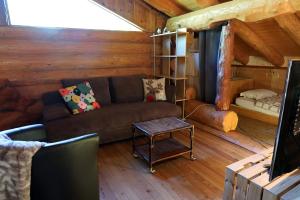 a living room with a couch in a log cabin at Le Gîte de Briey - Chalet complet in Chalais