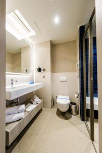 a bathroom with a white toilet and a sink at Altınorfoz Hotel in Ayaştürkmenli +47 photos