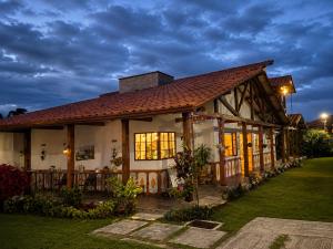 a house with a building with a roof at Balcón de Antioquia Exclusiva Villa Campestre con Piscina Privada, Jacuzzi y BBQ en el Eje Cafetero, cerca del Parque del Café in Montenegro