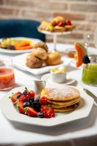 a table topped with plates of pancakes and fruit at Terme di Relilax Boutique Hotel & Spa - Adults Only in Montegrotto Terme +97 photos