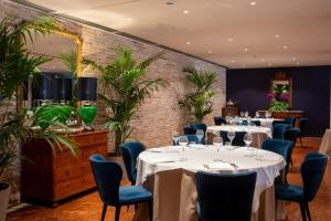 a restaurant with white tables and blue chairs at Terme di Relilax Boutique Hotel & Spa - Adults Only in Montegrotto Terme