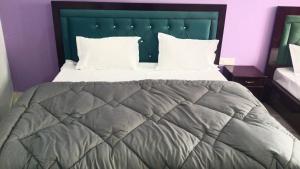 a large bed with a green headboard and white pillows at Tungnath View Homestay in Sari