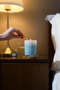 a person is lighting a candle on a table in a hotel room at NikolaosMare in Nea Potidaea