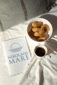 a bowl of nuts and a cup of coffee on a bed at NikolaosMare in Nea Potidaea