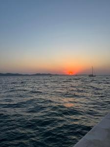a sail boat in the ocean at sunset at Eötvös Hotel in Ajka