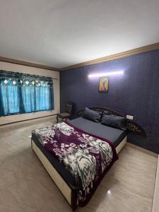 a bedroom with a bed and a blue wall at ROYAL budget Rooms in Ooty +37 photos