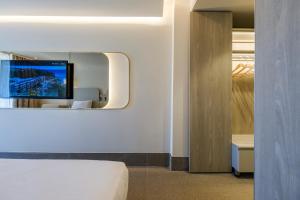 a hotel room with a bed and a mirror at Altınorfoz Hotel in Ayaştürkmenli