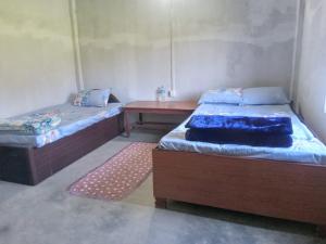a room with two beds and a table in it at Gobrela homestay in Bardiyā