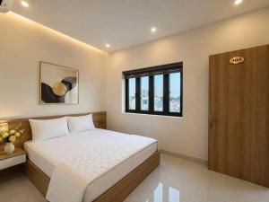 a bedroom with a white bed and a window at Luxury Hotel Long Thành in Xóm Nước Trong