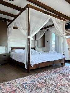 a bedroom with a canopy bed and a rug at Villa Myra in Beymelek