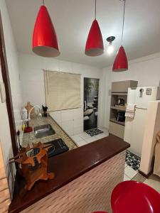 a kitchen with red pendant lights over a kitchen counter at Hospedagem Dorna Casa 6A Itaguaí in Itaguaí +20 photos