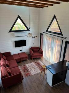 a living room with a couch and a tv at Villa Myra in Beymelek