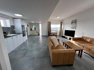 a living room with two couches and a kitchen at carmel cabins suite 12 in Yājur