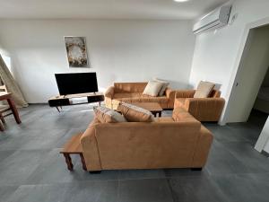 a living room with two couches and a flat screen tv at carmel cabins suite 12 in Yājur
