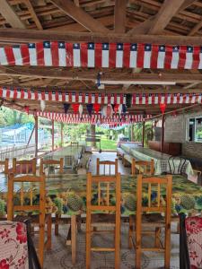 ein Essbereich im Freien mit Tischen und Stühlen und einer amerikanischen Flagge in der Unterkunft Camping Las Torcacitas in Yerbas Buenas