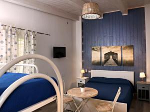 a bedroom with a blue bed and a table at Beatrice Home in Pompei