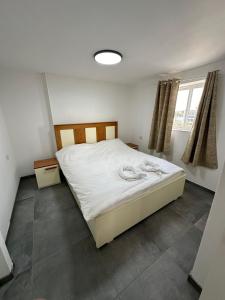 a bedroom with a bed with white sheets and a window at carmel cabins suite 12 in Yājur +18 photos