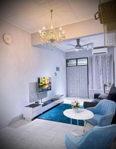 a living room with a chandelier and a blue rug at M & V butterworth in Butterworth