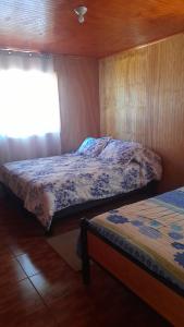 ein Schlafzimmer mit zwei Betten und einem Fenster in der Unterkunft Camping Las Torcacitas in Yerbas Buenas