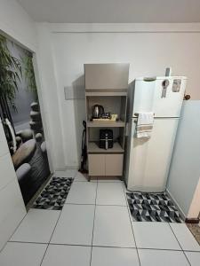 a small kitchen with a refrigerator and a tiled floor at Hospedagem Dorna Casa 6A Itaguaí in Itaguaí