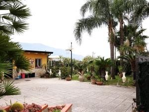 a courtyard with palm trees and a house at Beatrice Home in Pompei