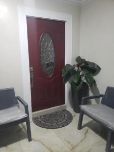 a red door with a potted plant next to two chairs at Kami's serenity suit in Port Maria