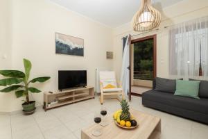 a living room with a couch and a tv at Casa Stefanos in Afitos +82 photos
