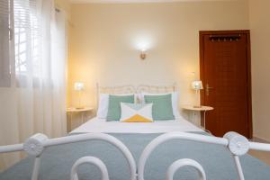 a bedroom with a white bed with colorful pillows at Casa Stefanos in Afitos
