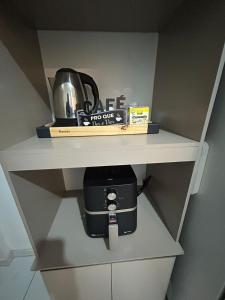 a cupboard with a coffee pot on top of it at Hospedagem Dorna Casa 6A Itaguaí in Itaguaí