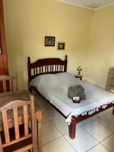 a bedroom with a bed and a table and chairs at Na Boca do Jacaré in Caraguatatuba