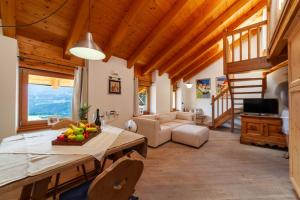 a kitchen and living room with a table and a couch at Residenza Bagni & Miramonti in Cavalese