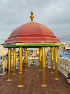 a red and yellow gazebo with yellow poles at Umbrella Comfy Stays-Subbu in Madurai
