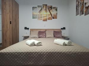 a bedroom with a bed with two towels on it at Apartman Studio Nicky in Mlini