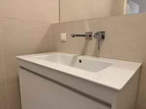 a white sink in a bathroom with a mirror at Modern Apartment in Döbling in Vienna