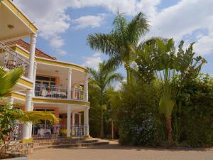 a house with a palm tree in front of it at DANA KIGALI HOTEL in Kigali