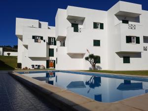 a white building with a pool in front of it at O Paraíso no Terraço in Foz do Arelho