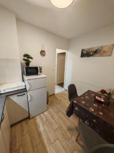 a small kitchen with a refrigerator and a table at Apartman Studio Nicky in Mlini