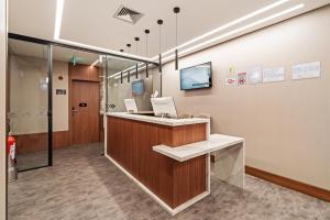 an office lobby with a reception desk and a tv at Fast Sleep Guarulhos by Slaviero Hotéis in Guarulhos