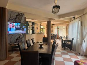 a dining room with a table and a tv at Vila George in Eforie Sud +16 photos